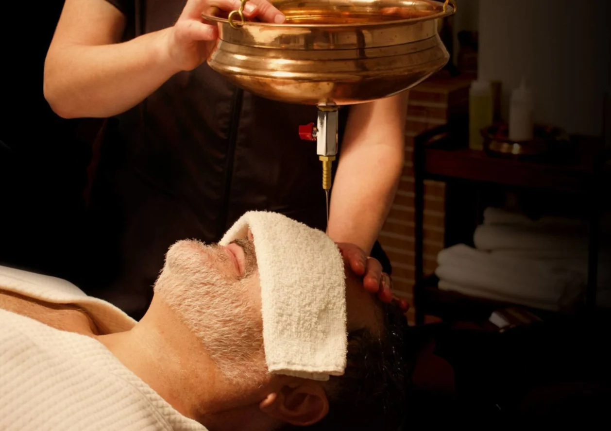 Male spa guest getting shirodhara treatment at YO1 Health Resort